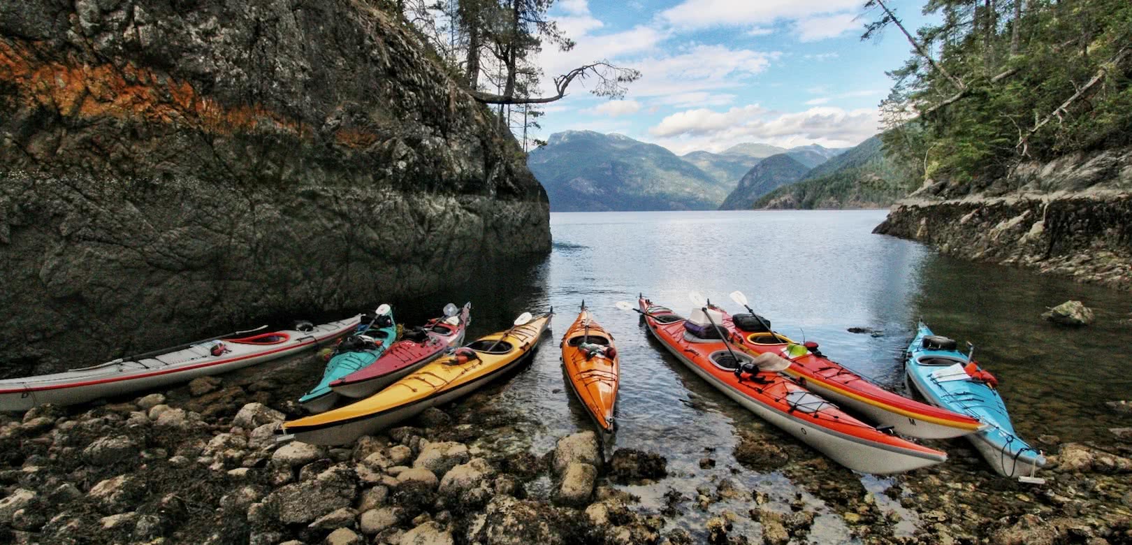 Kayaks in a calm bay on one of our sea kayak expeditions