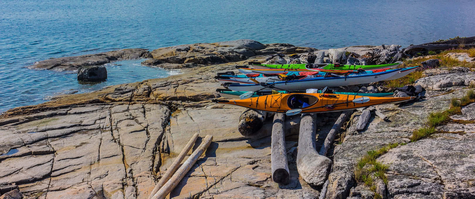 kayaks resting on logs