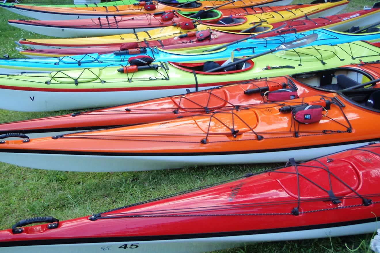 Colourful sea kayak rentals lined up in Okeover Inlet