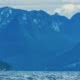 A kayaker sits and looks at the Coast Mountains on one of our multi-day kayak tours