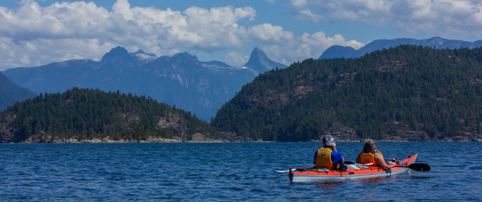 Two kayakers gaze up at Mount Denman in Homfray Channel near Toba Inlet