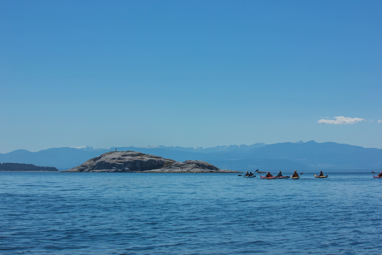 A group of sea kayakers paddling to Major Rock near the Copeland Islands