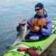 A guest after a successful catch of Salmon from a kayak in Desolation Sound