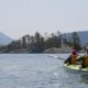 Two paddlers in a double kayak approaching the Curme Islands in Desolation Sound
