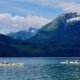 A group of kayakers paddling beneath the huge whitecapped peaks in Toba Inlet