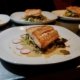 A meal of local salmon and fresh local vegetables being plated in the kitchen at Cabana Desolation Eco Resort