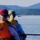 Two kayakers sitting and watching a humpback whale in the distance in Desolation Sound