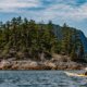 A kayaker paddling in front of a small island at the entrance to Teakerne Arm on West Redonda Island