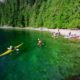 Kayakers landing after a long day of paddling in a remote camp in Lewis Channel on West Redonda Island on one of our sea kayak expeditions