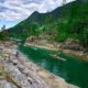 A group of kayakers paddle through a narrow channel near the campsite at Walsh Cove