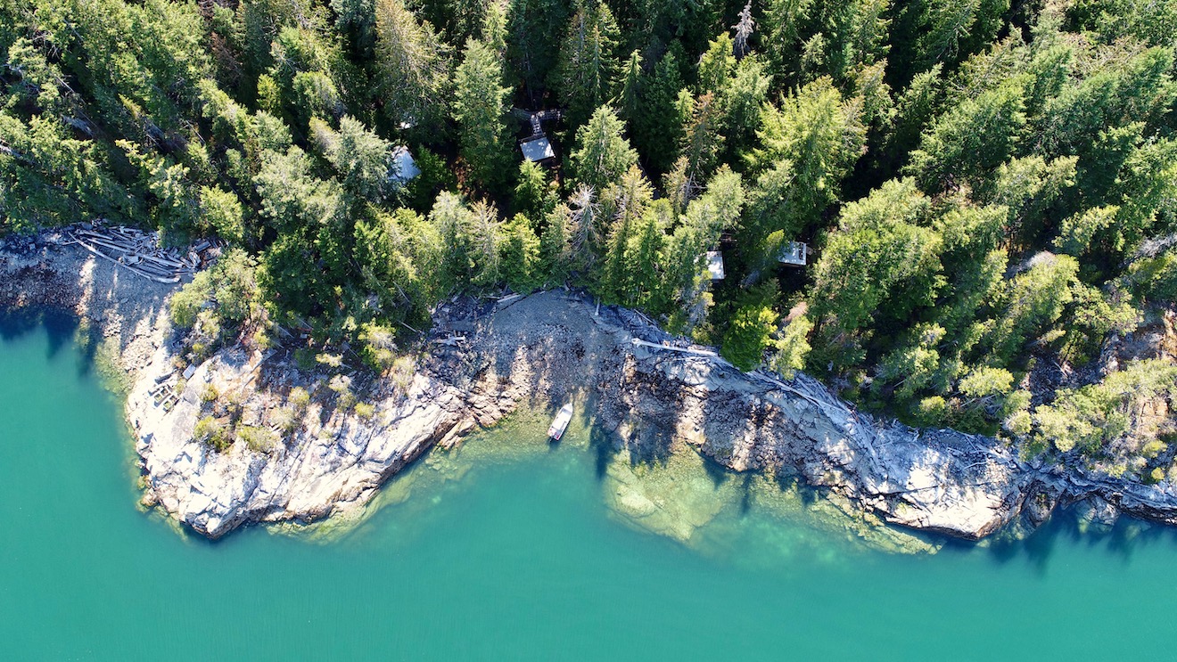 view of blue water and cabins from above