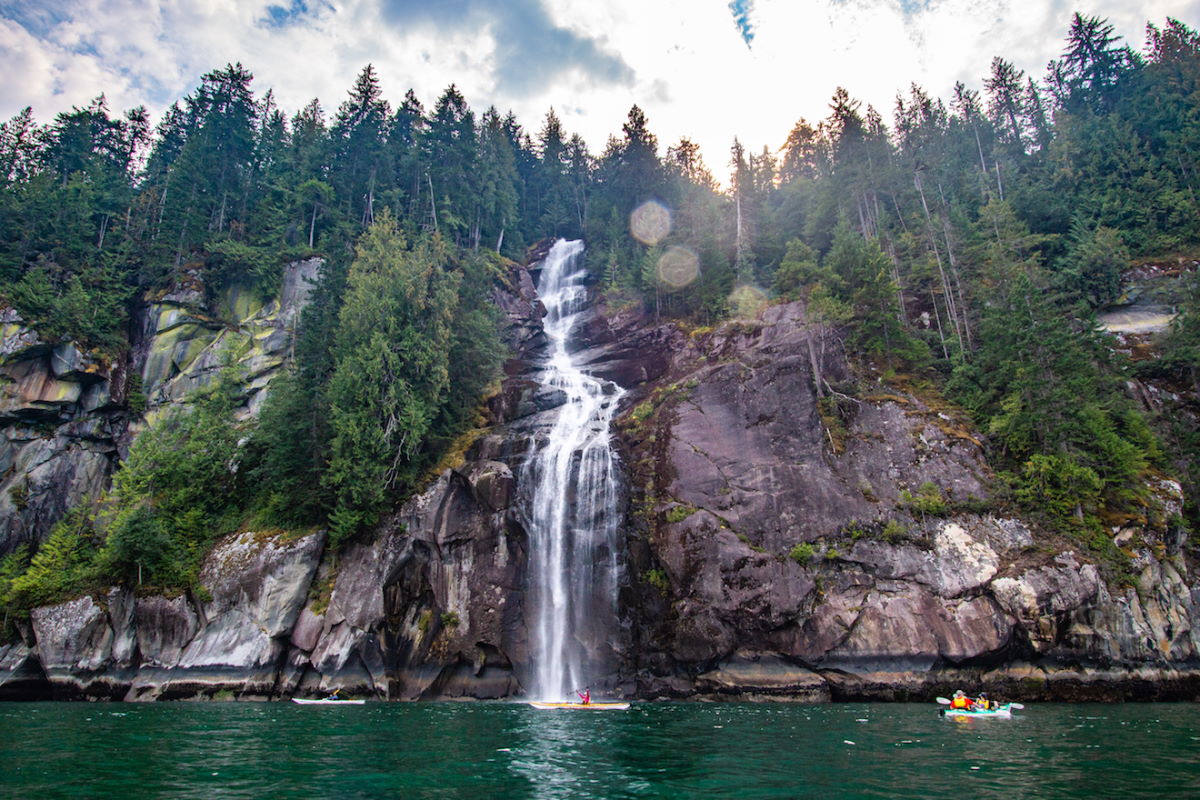 kayaking under epic waterfall